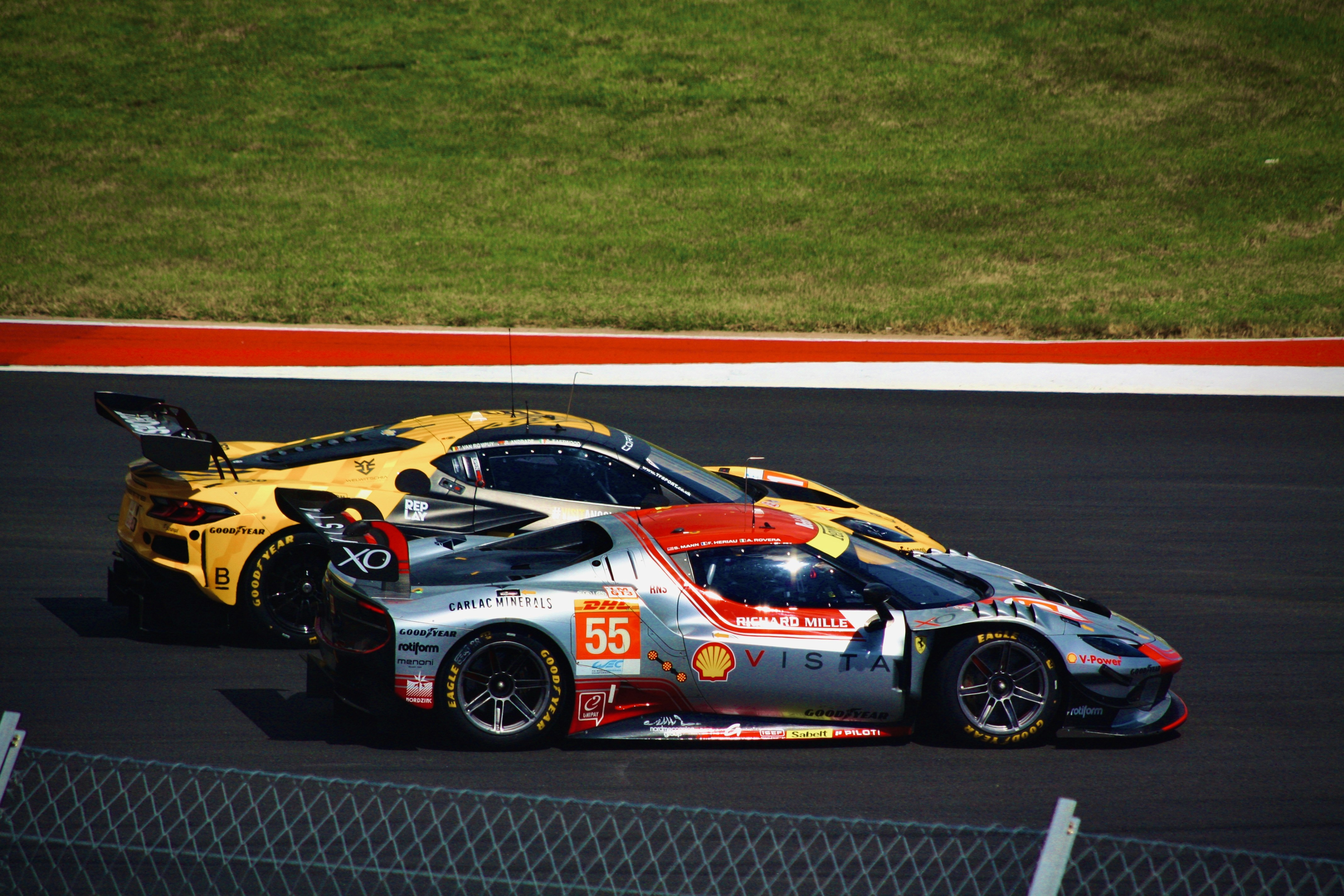 Race cars speed along the track.
