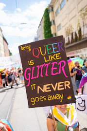 Person holds a sign at a pride parade.