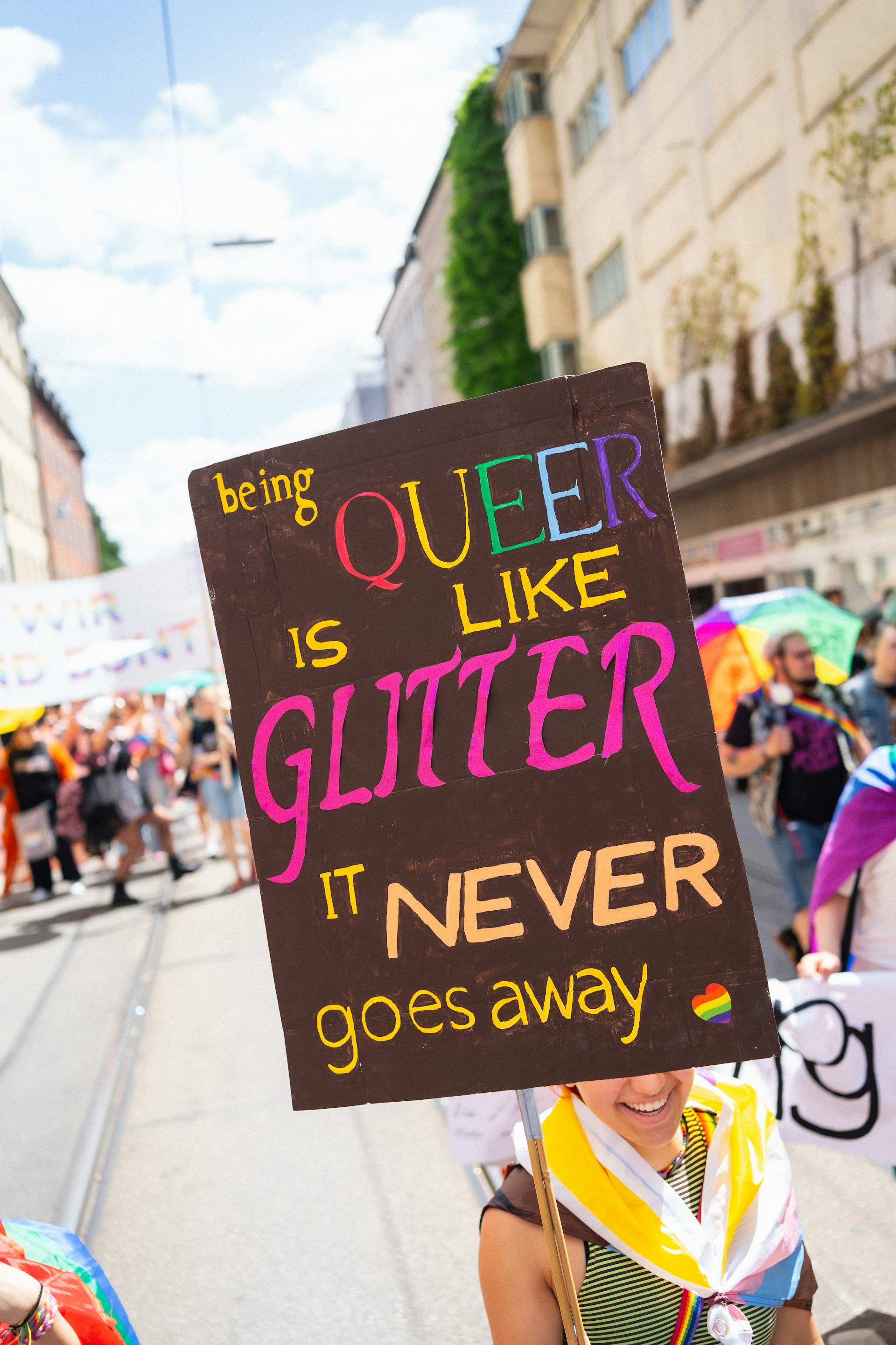 Person holds a sign at a pride parade.