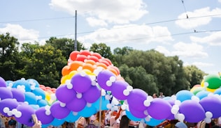 A pride parade arch made of colorful balloons.