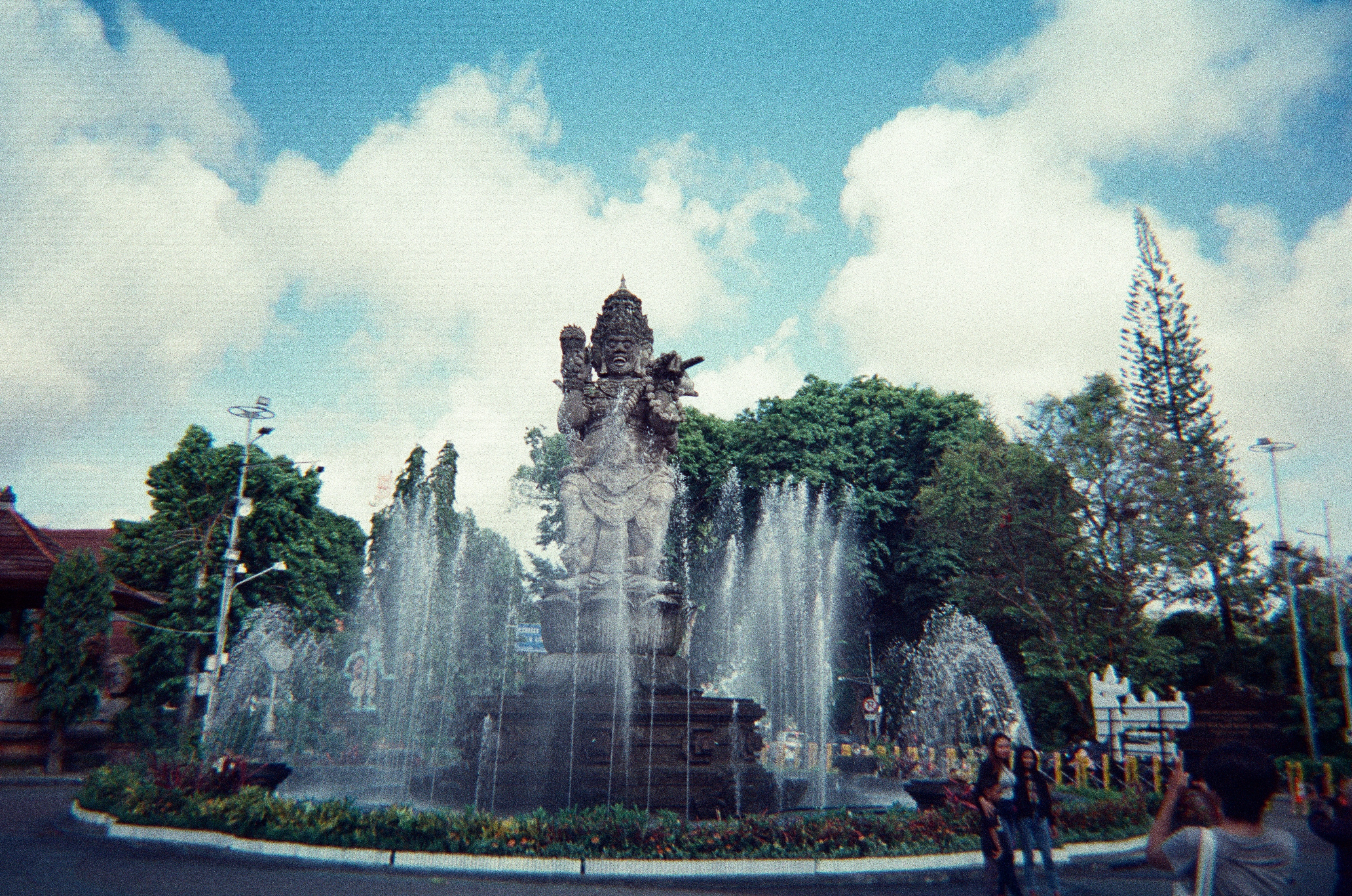Wide-angle shot of the iconic Catur Muka statue and fountain, located at the 0 kilometer point in Denpasar City, Bali. A cultural and historical symbol of the Balinese capital.