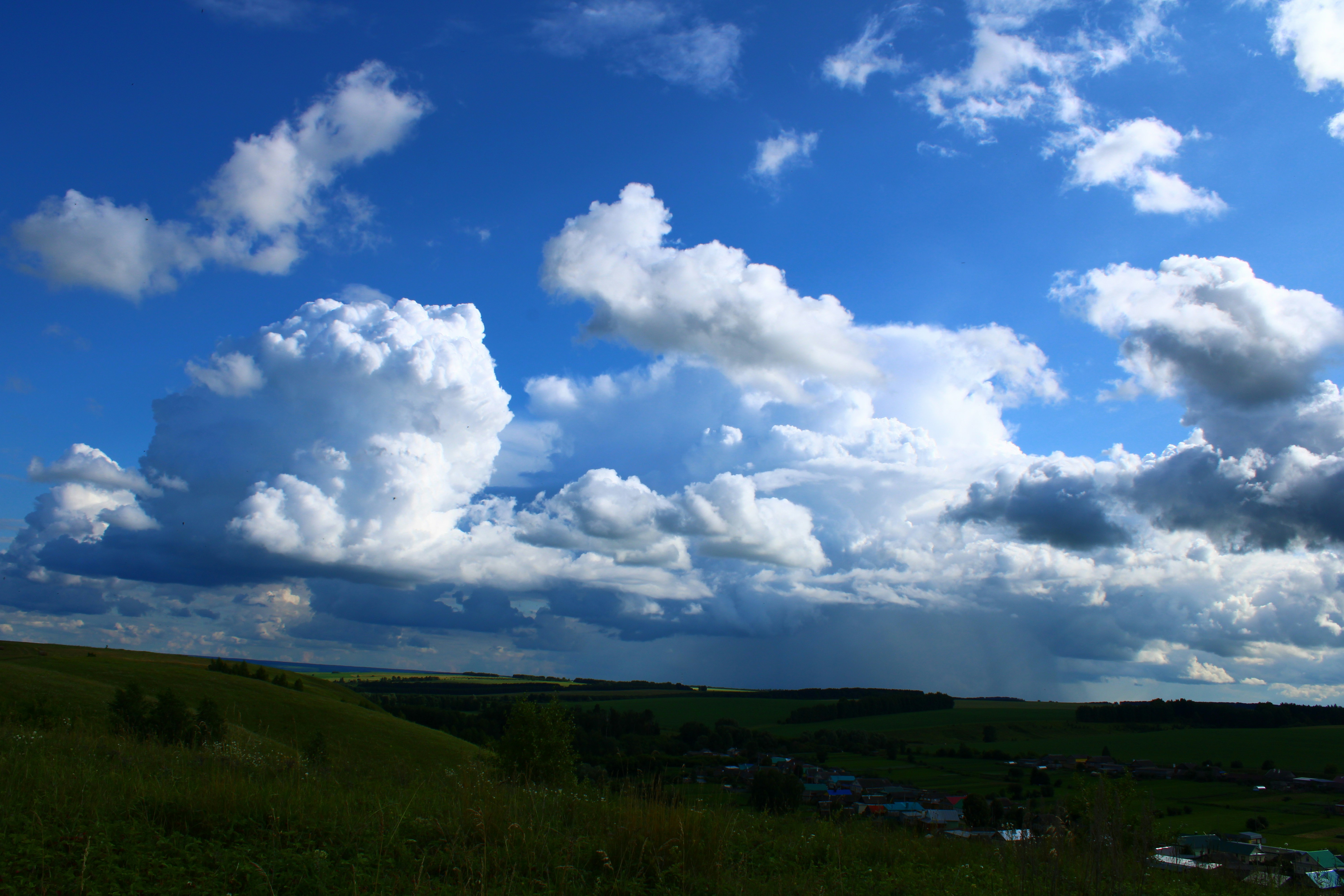 蓝天白云下翠绿山峦中的小院民宿美景