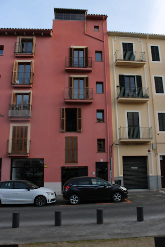 Colorful buildings stand next to parked cars on the street