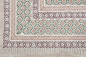A decorative rug with geometric and floral patterns.
