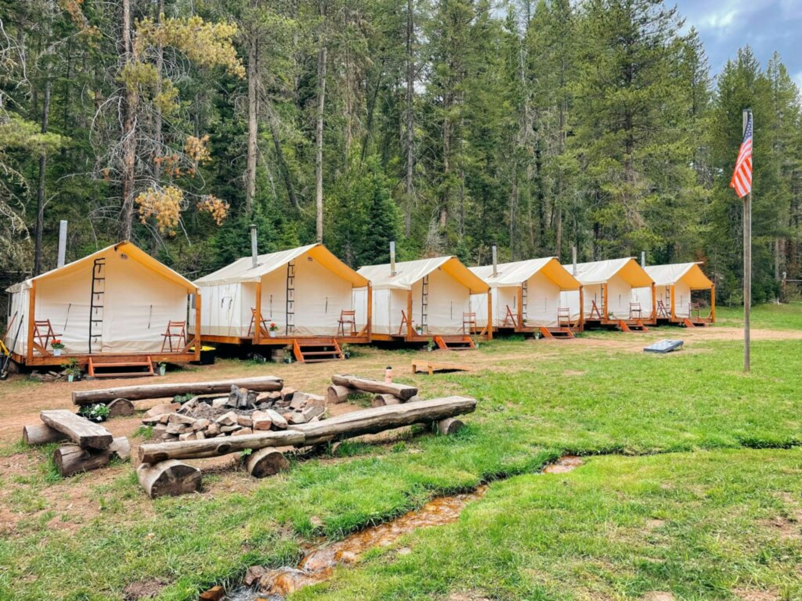 Camping tents are set up in a grassy area