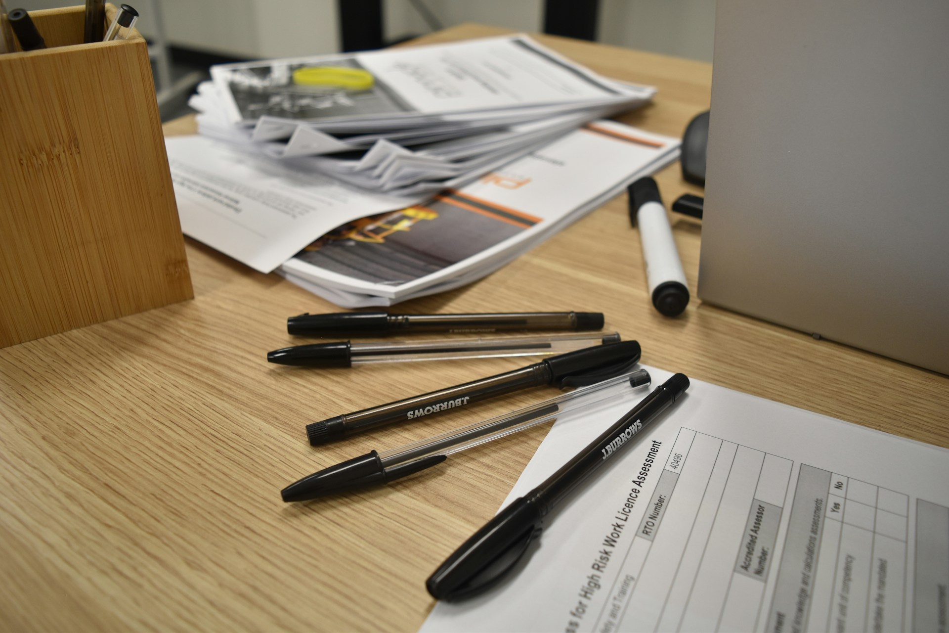 Papers and pens are spread on a desktop.