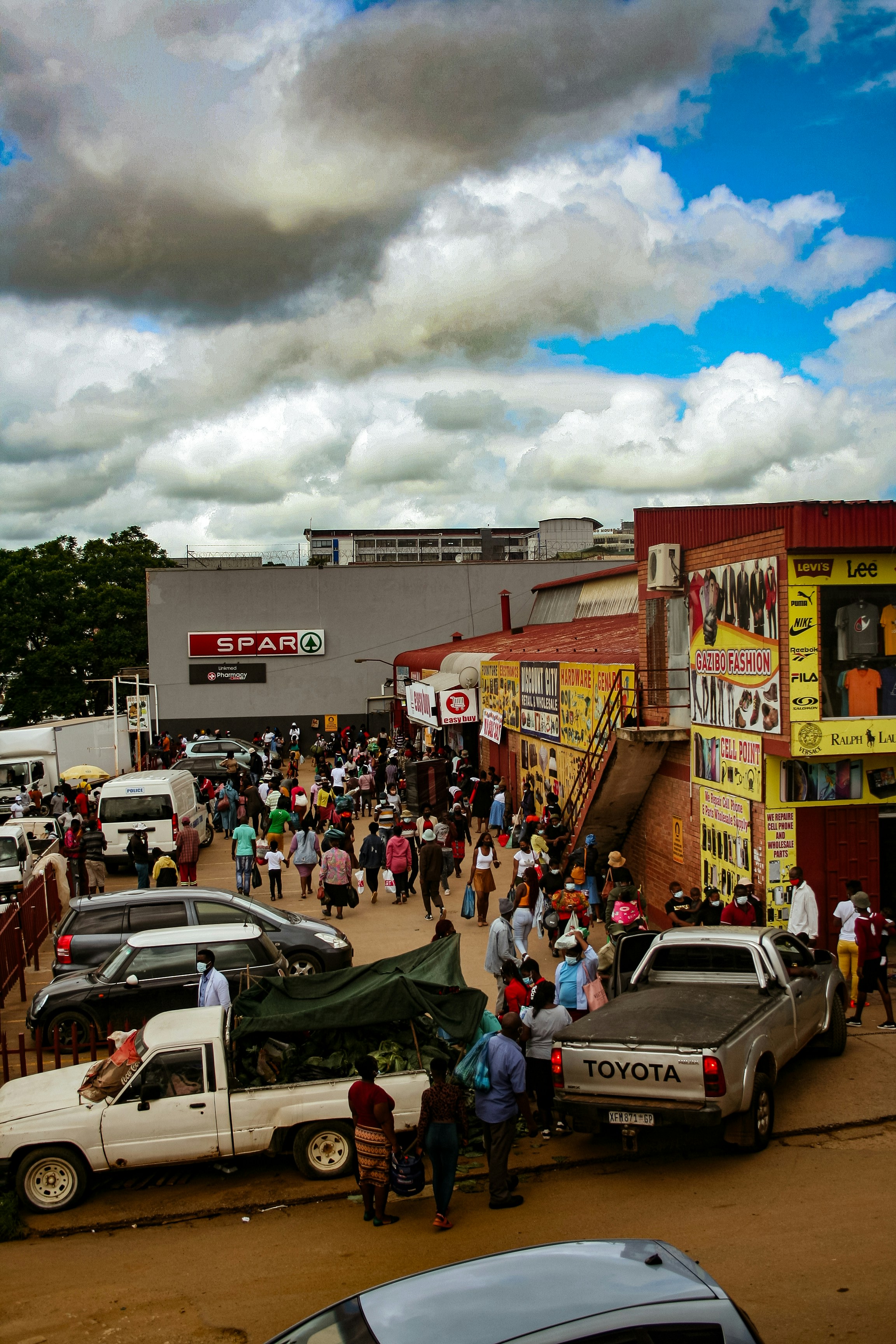 People shop and walk in a busy outdoor market.