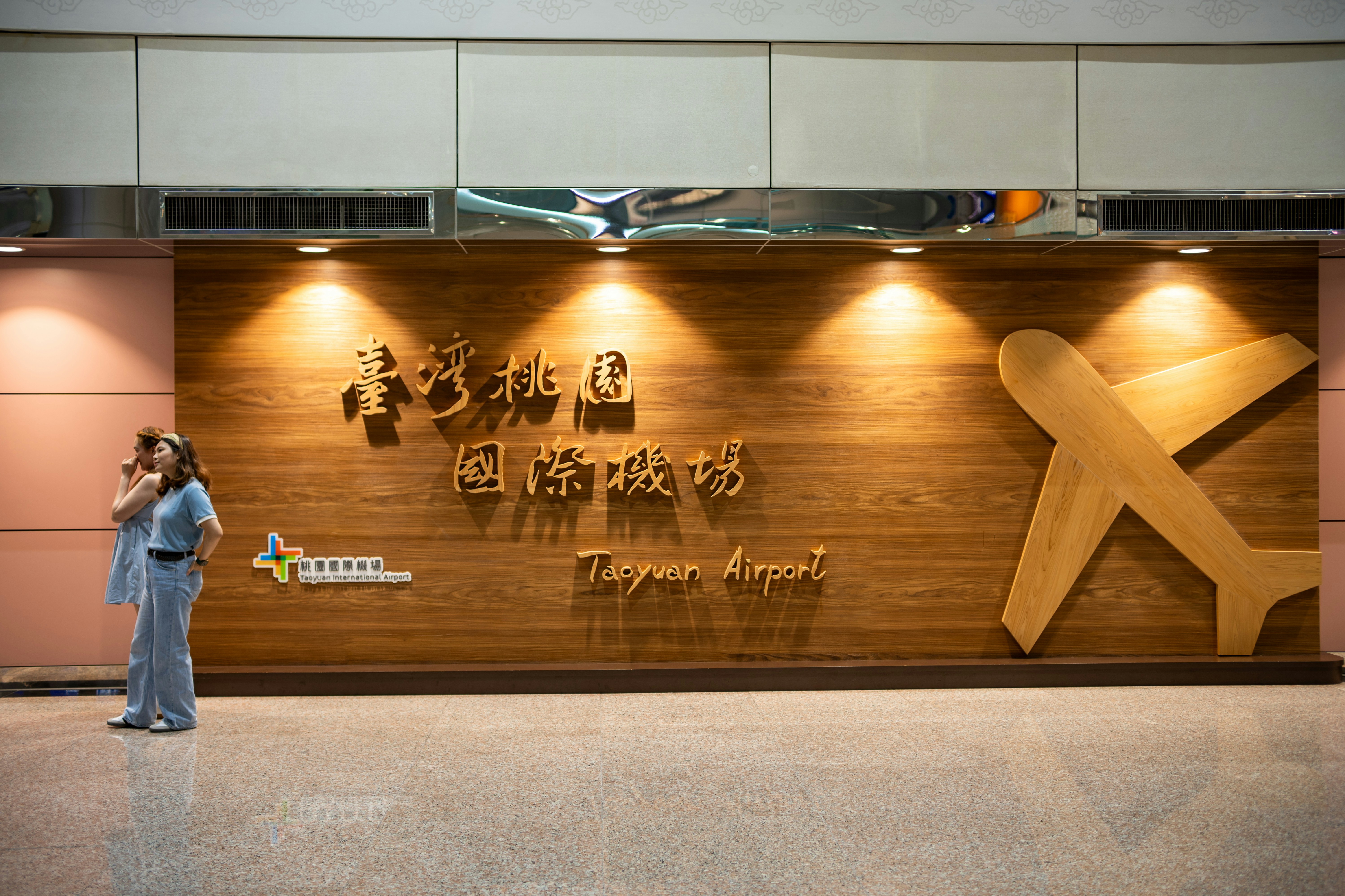 People stand near the taoyuan airport sign.