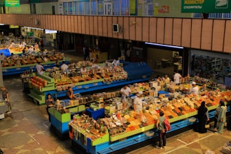 Busy market stalls display colorful food items.
