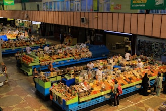 Busy market stalls display colorful food items.