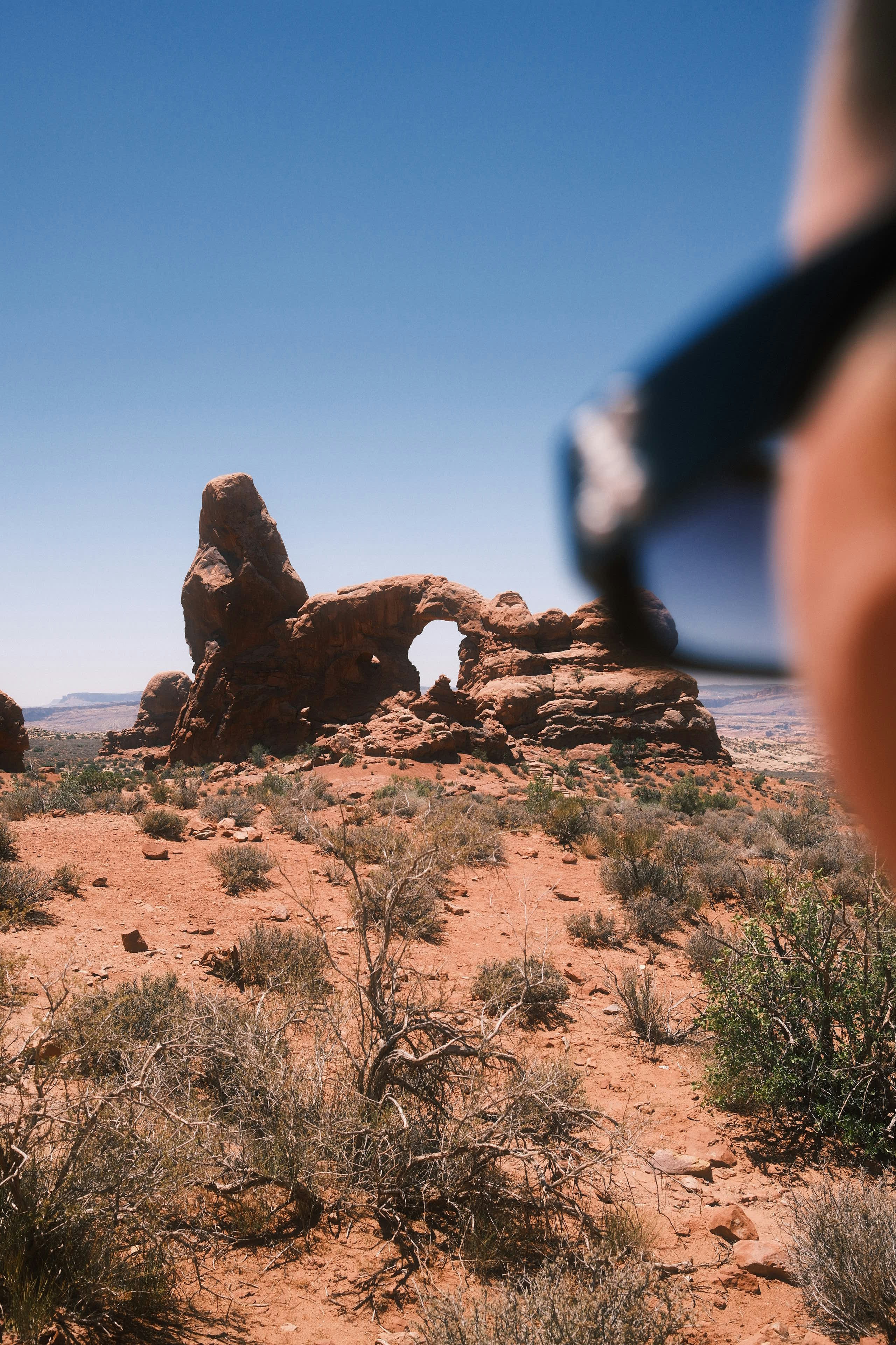 A stone arch stands tall amidst the desert.