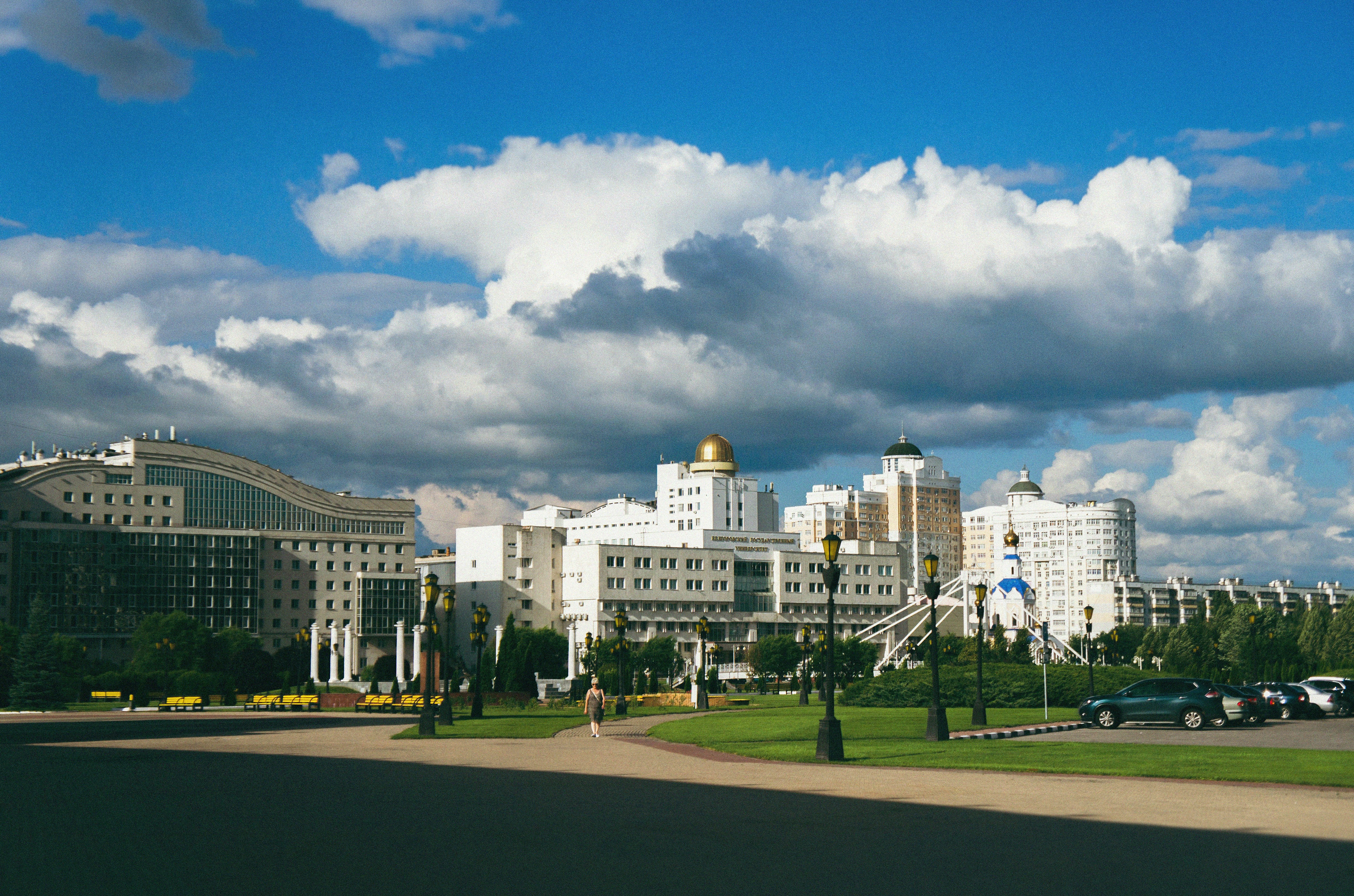Buildings and clouds fill a beautiful, sunny cityscape.