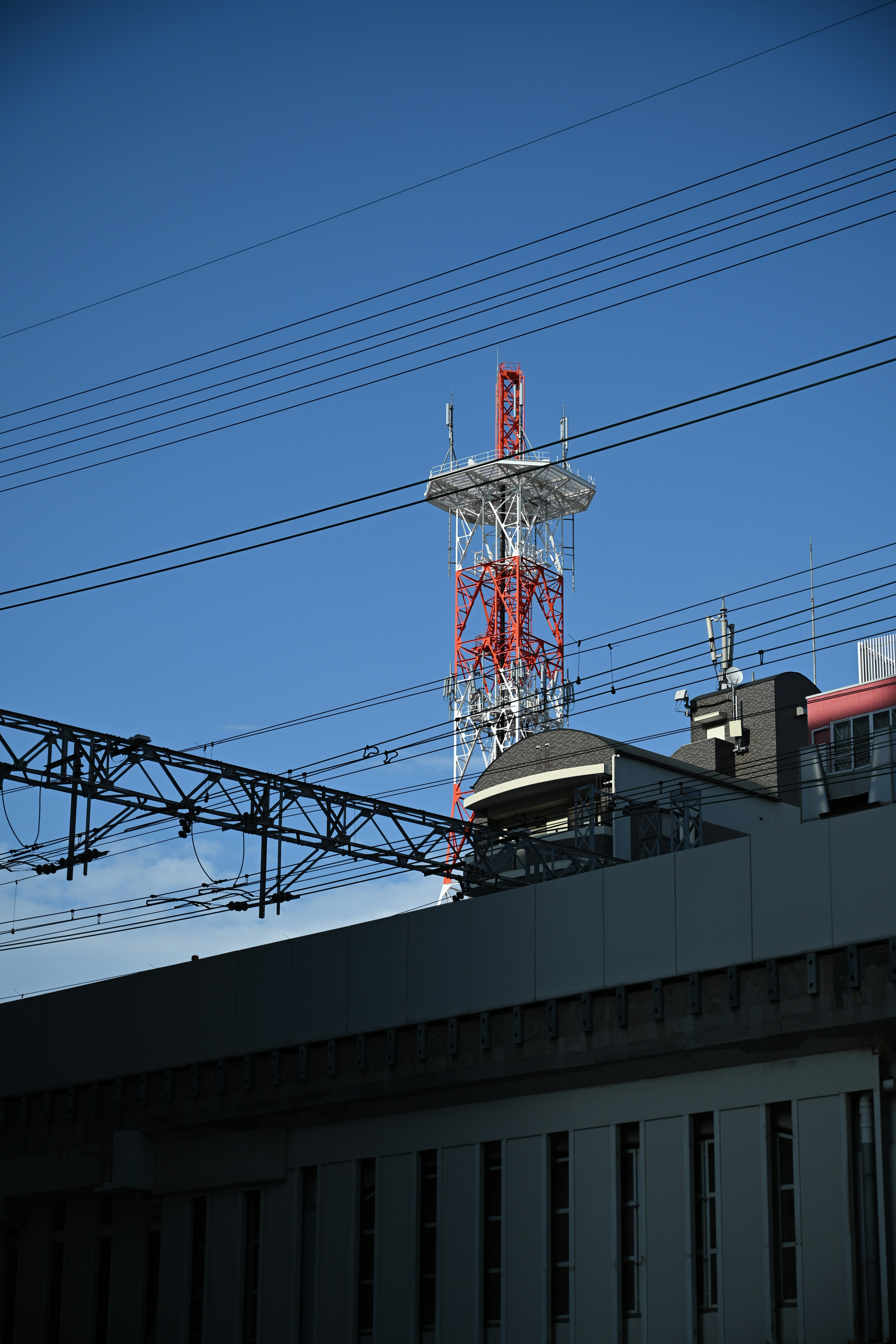 A tall communication tower stands against a blue sky.