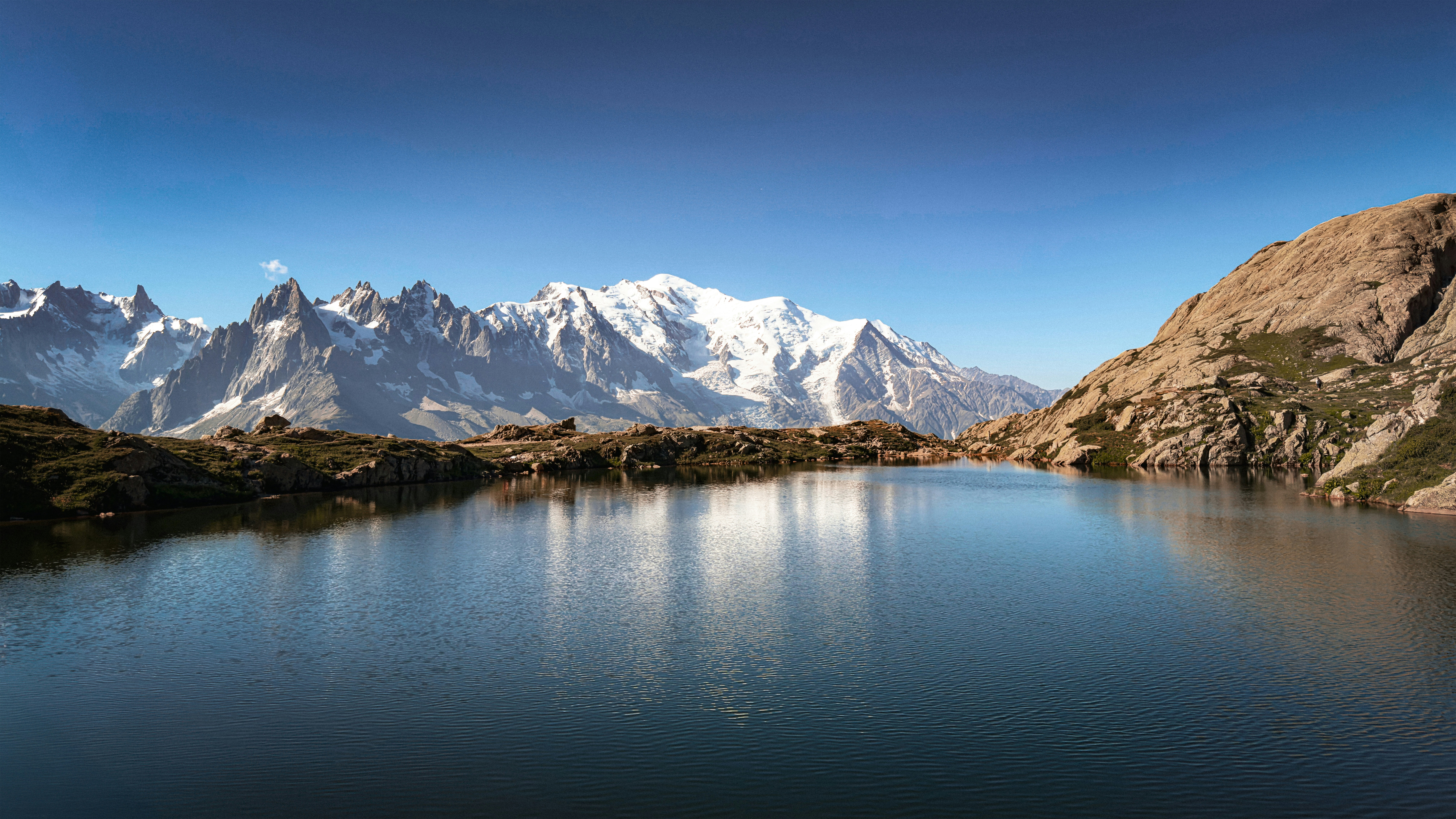 Mountains reflect in a calm lake.