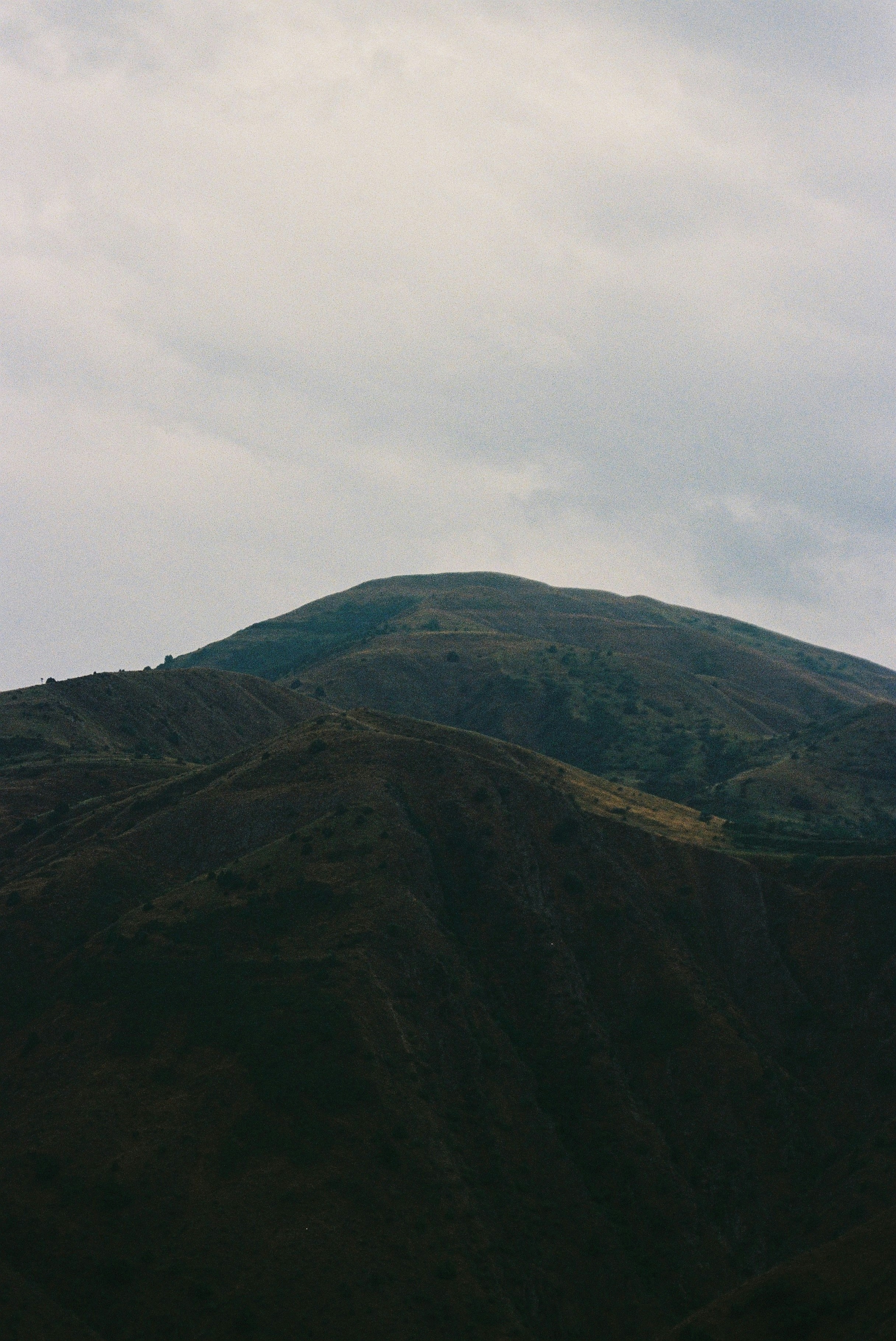 Mountains rise dramatically under a cloudy sky.