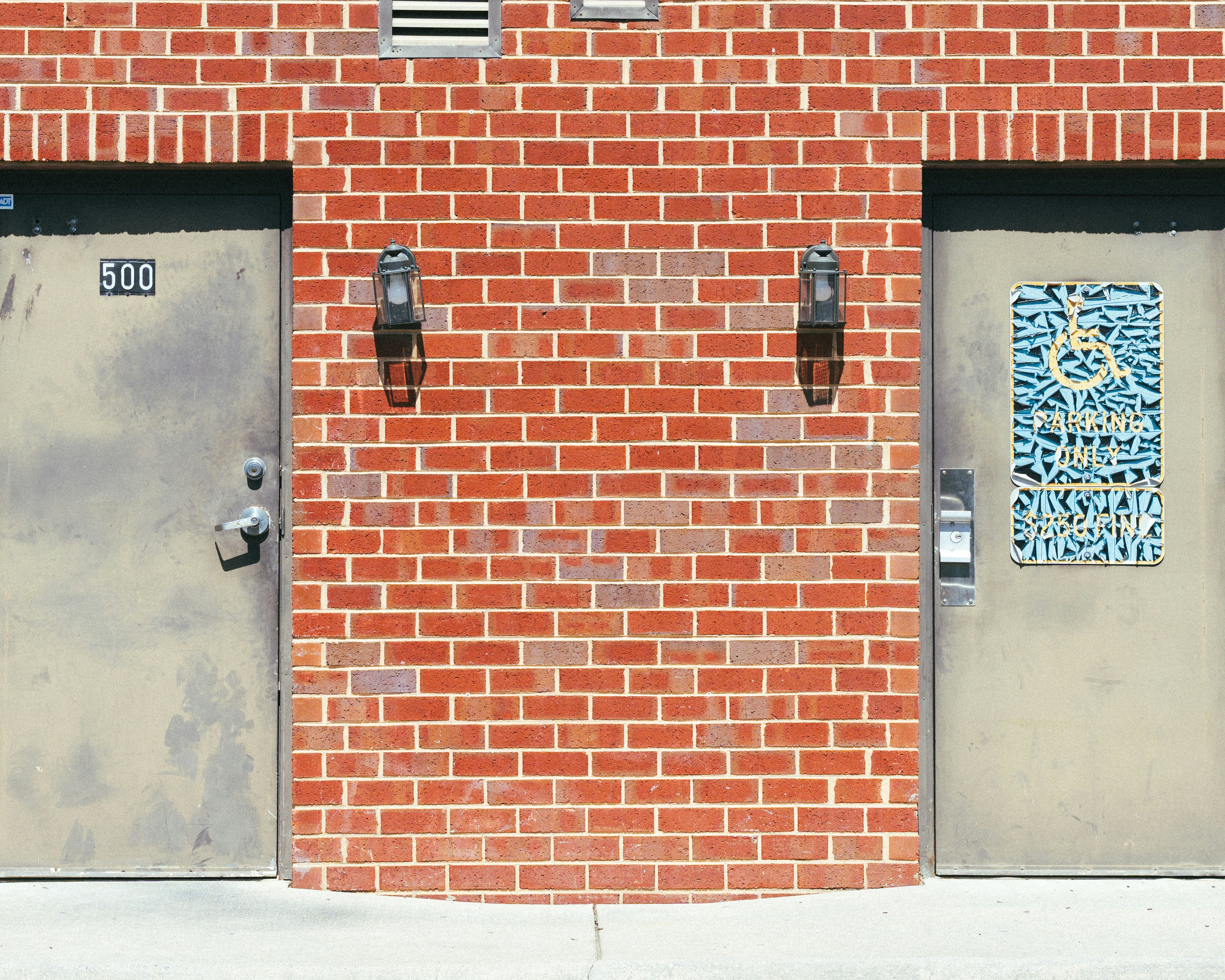Doors on either side of a brick wall.