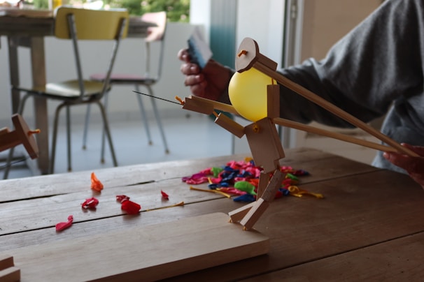 A wooden figure is shooting a water balloon.