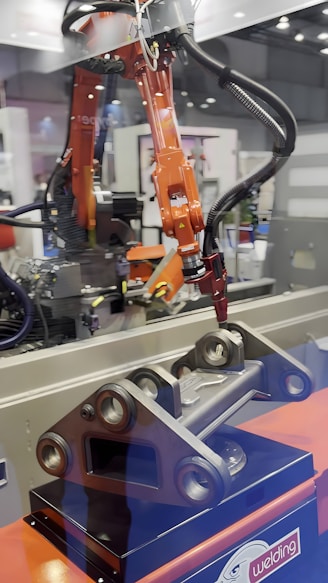 A robotic arm welds a metal part.