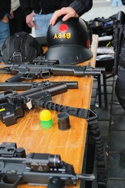 Guns and gear are laid out on a table.