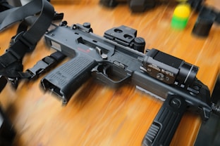 A modified firearm rests on a wooden surface.