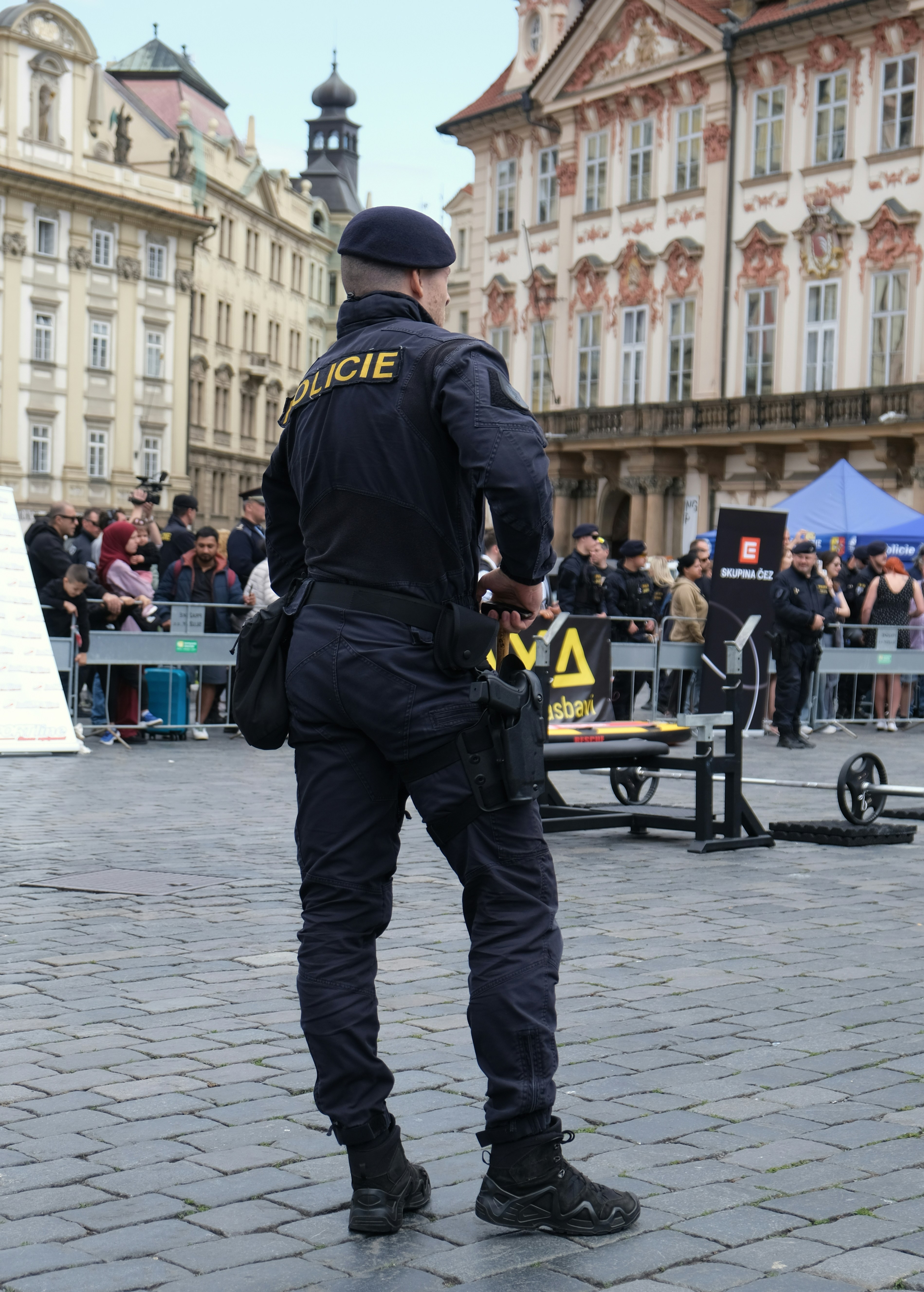 A police officer stands in a crowded public square.