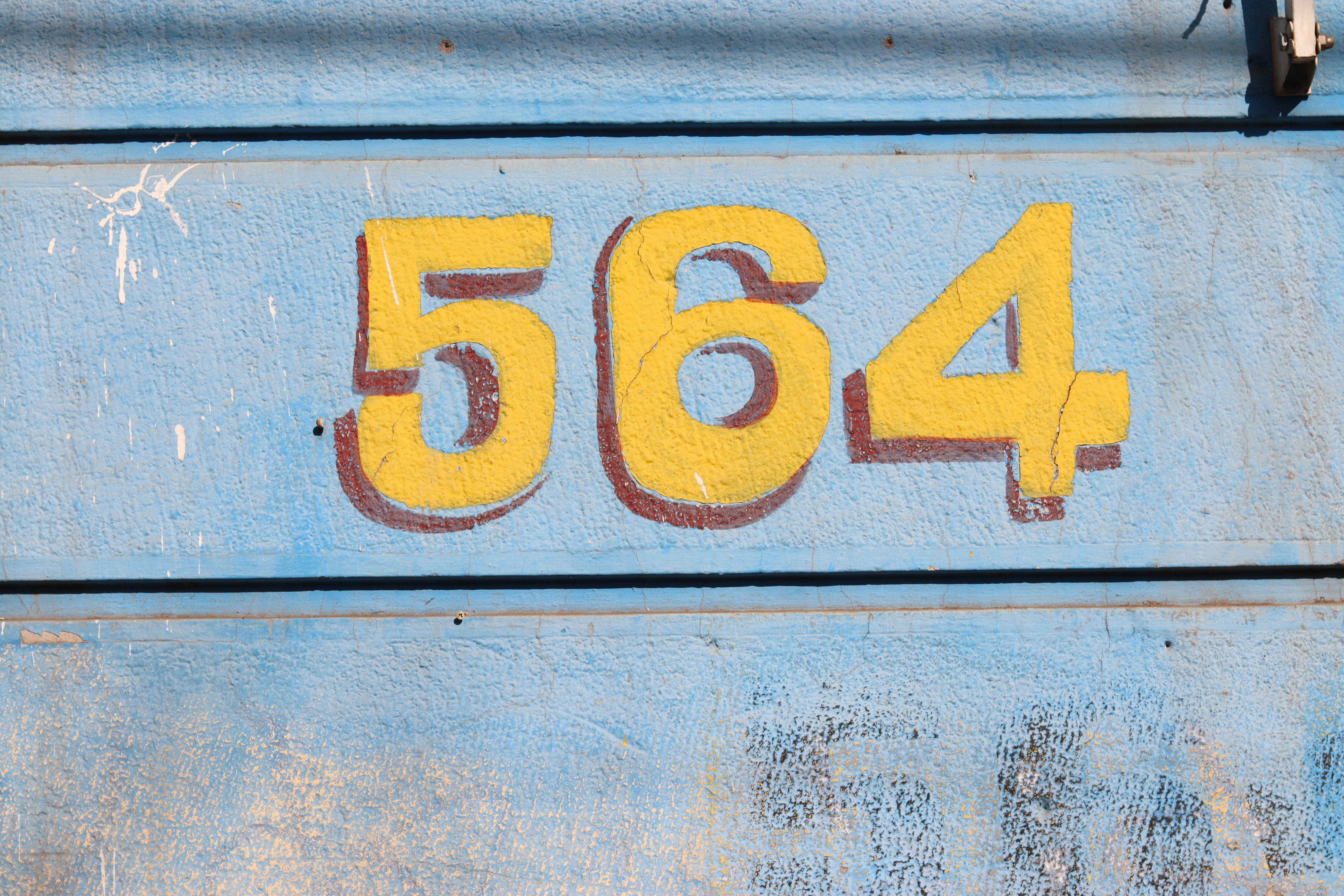Numbers 564 are painted on a blue surface.