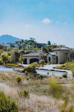 A luxurious house sits in a sunny landscape.