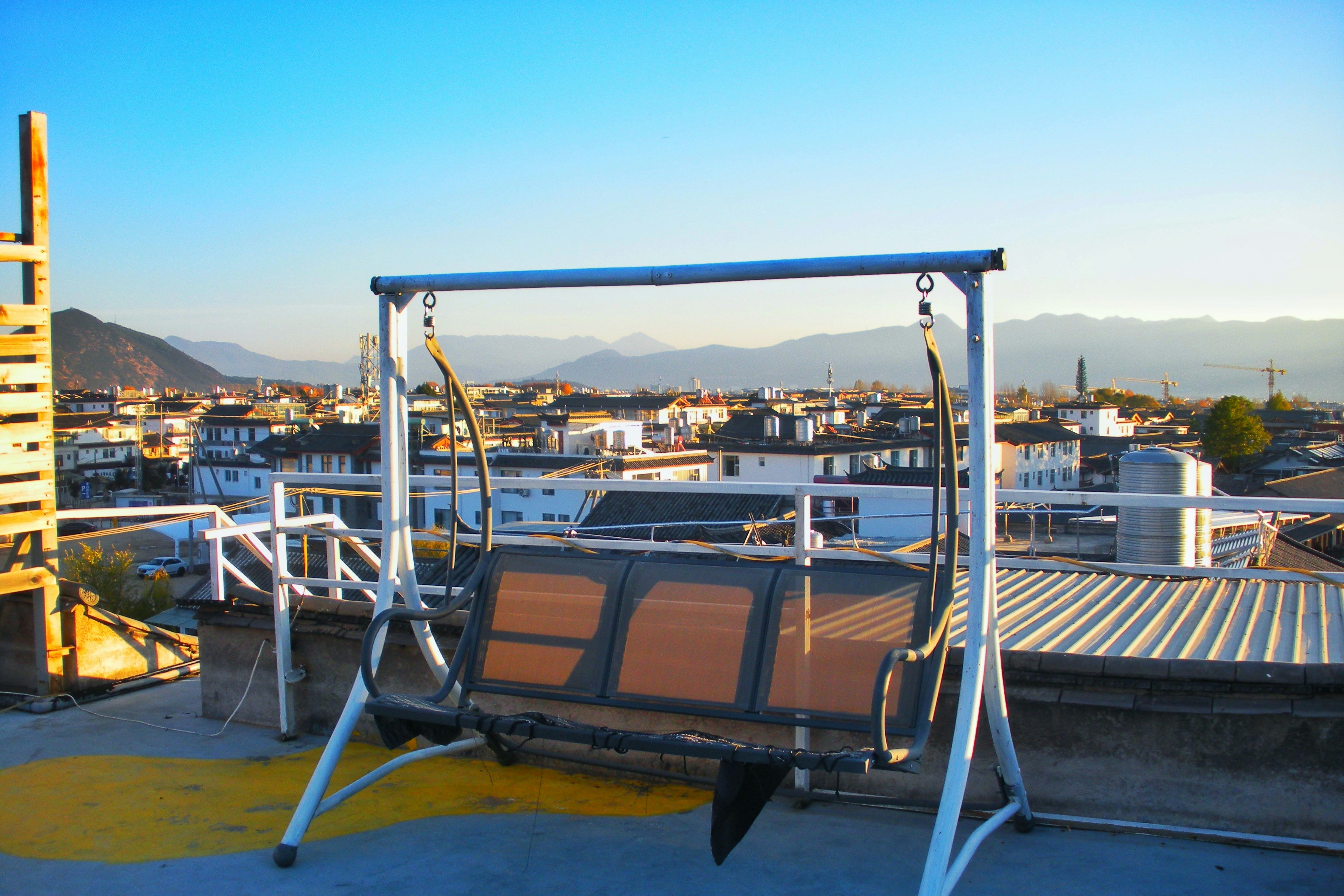 Swing set on a rooftop overlooking a cityscape.