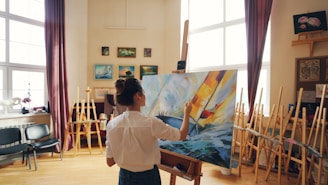 An artist is painting a picture in her studio.