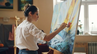 A woman is painting on a canvas.