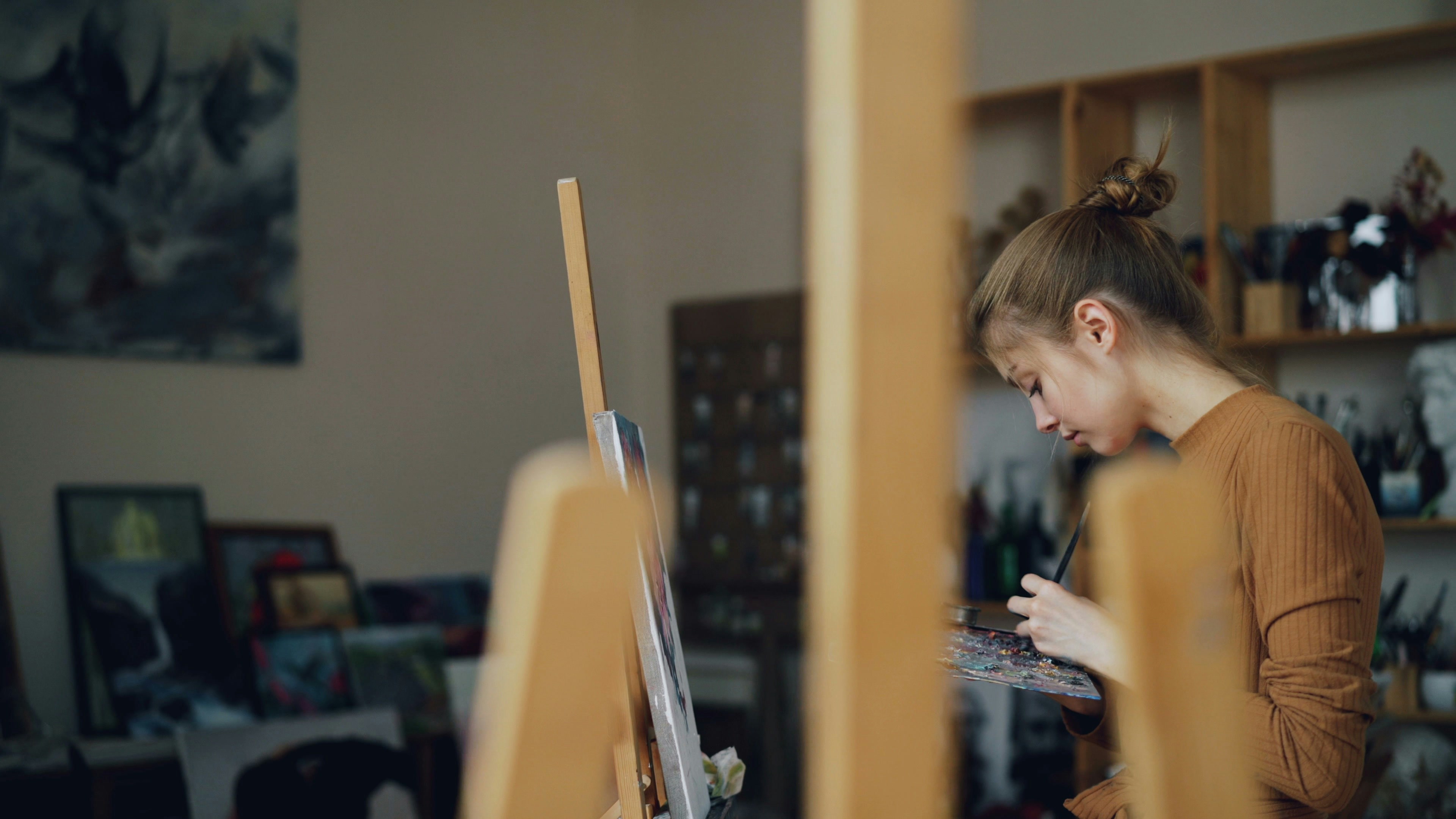 A teen enjoying a creative hobby, like painting or playing an instrument - cool gifts for teens