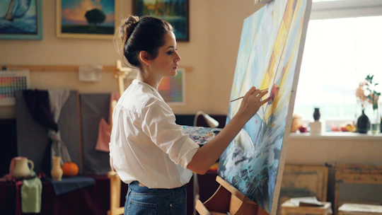A woman paints a picture in her art studio.