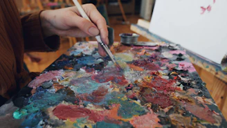Someone is mixing paints on an artist's palette.