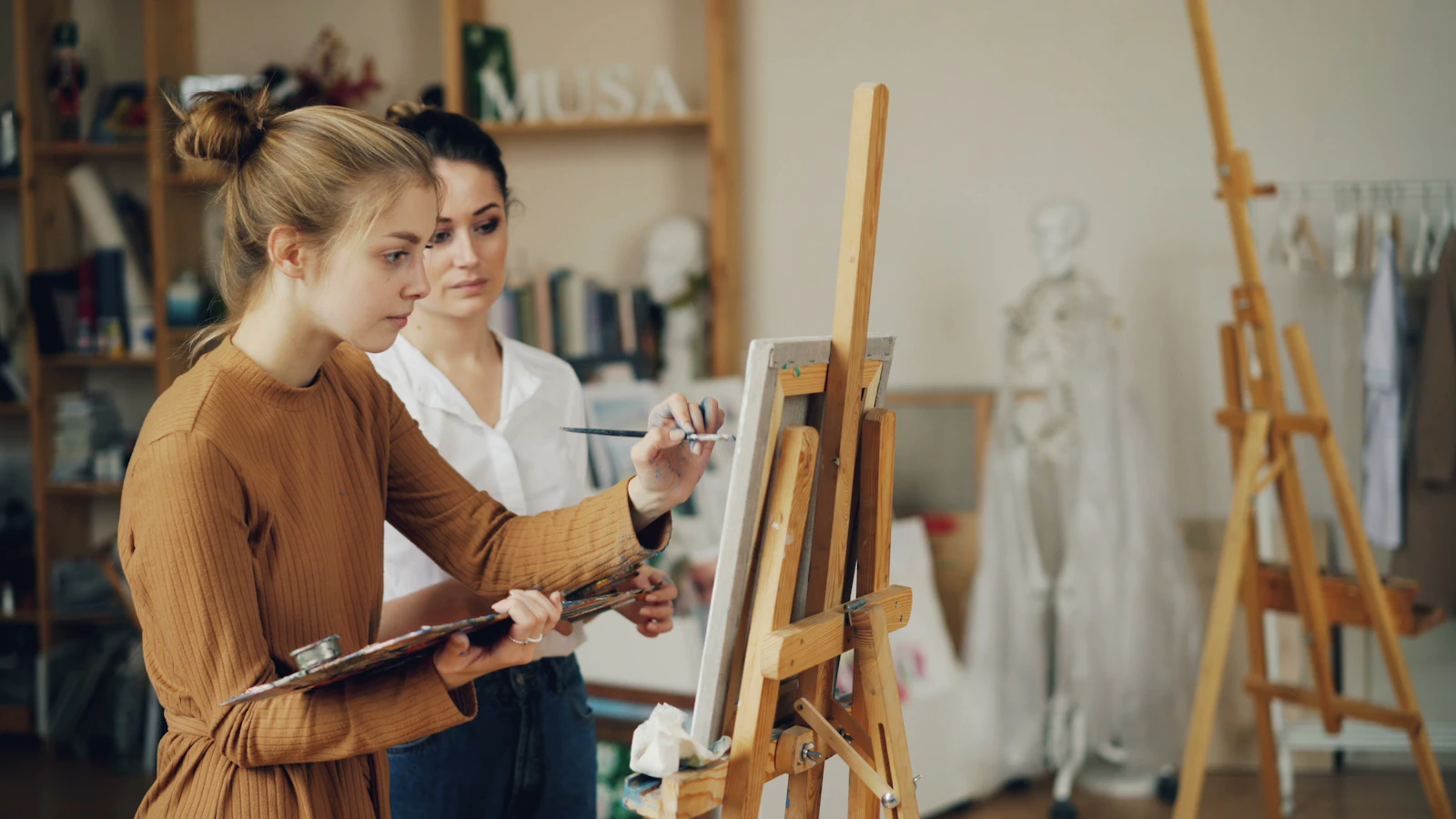Two artists painting together in an art studio