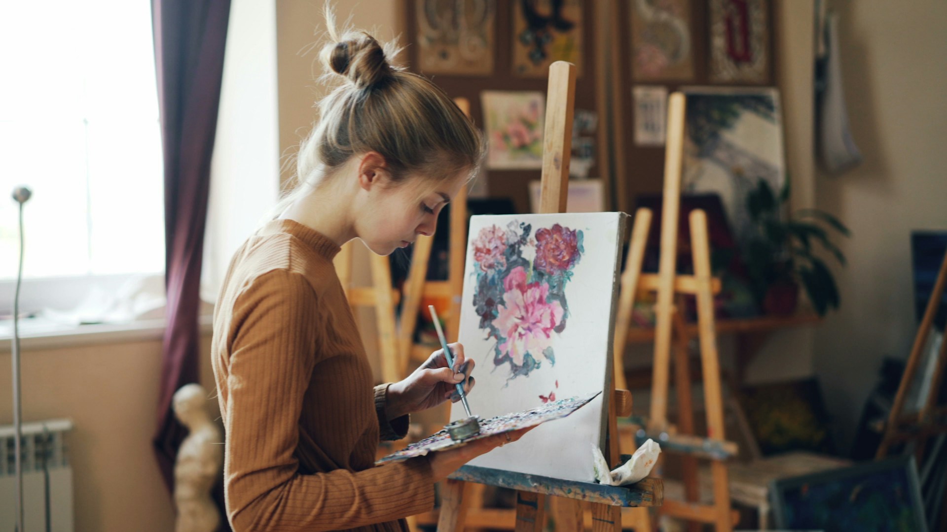 Artist painting flowers in her studio.