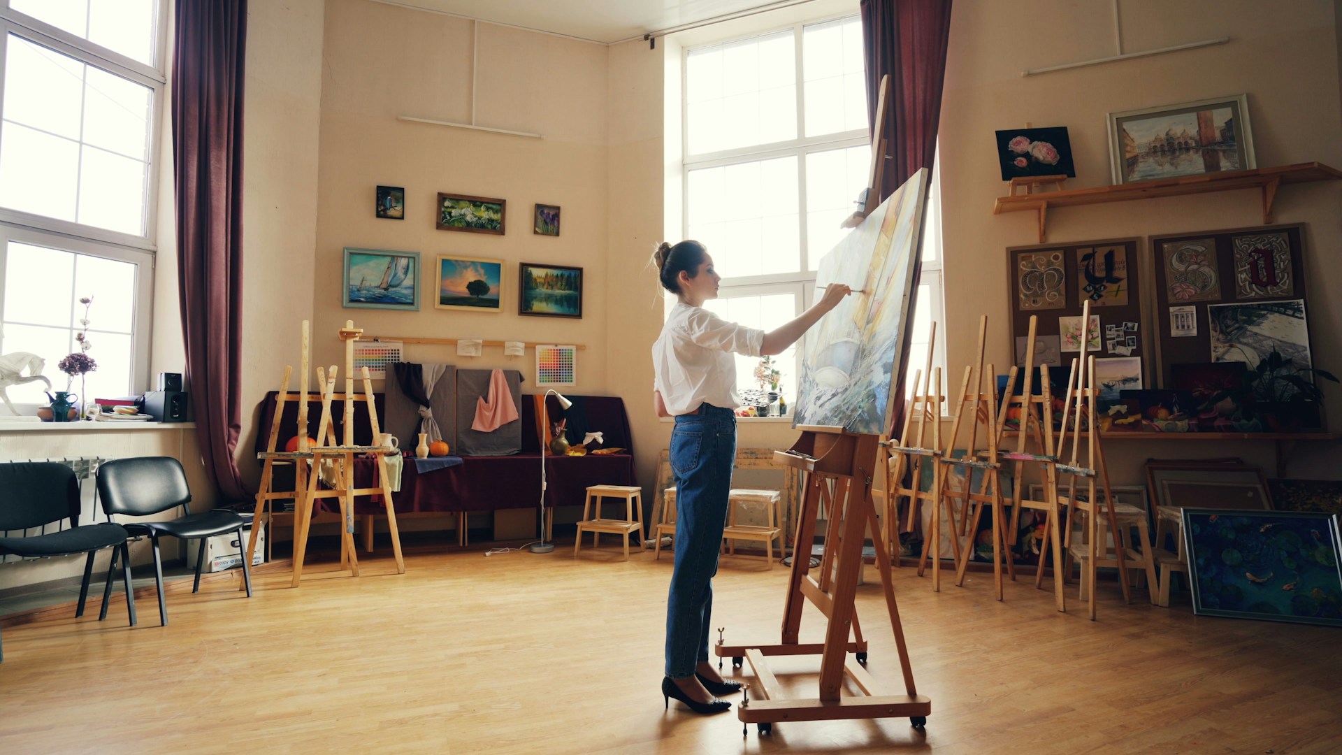 Artist working on a painting in a studio.