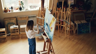 A woman paints in an art studio.