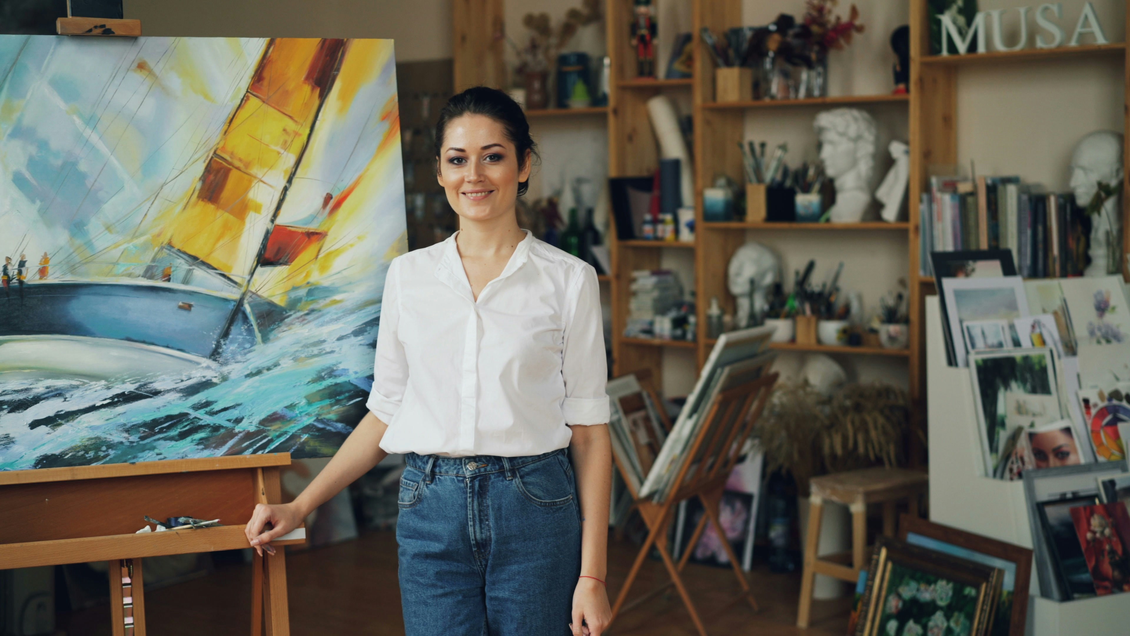 A female artist stands in her art studio.