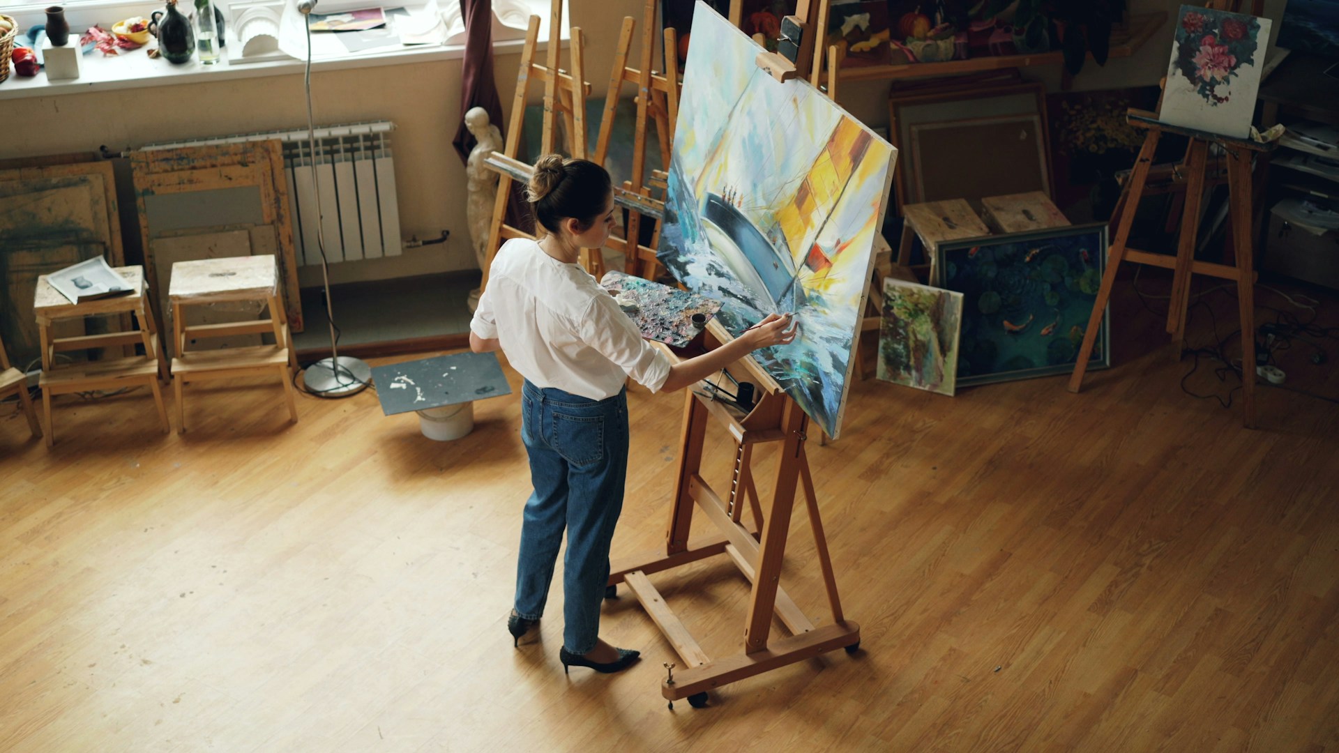 A woman paints a canvas in her studio.