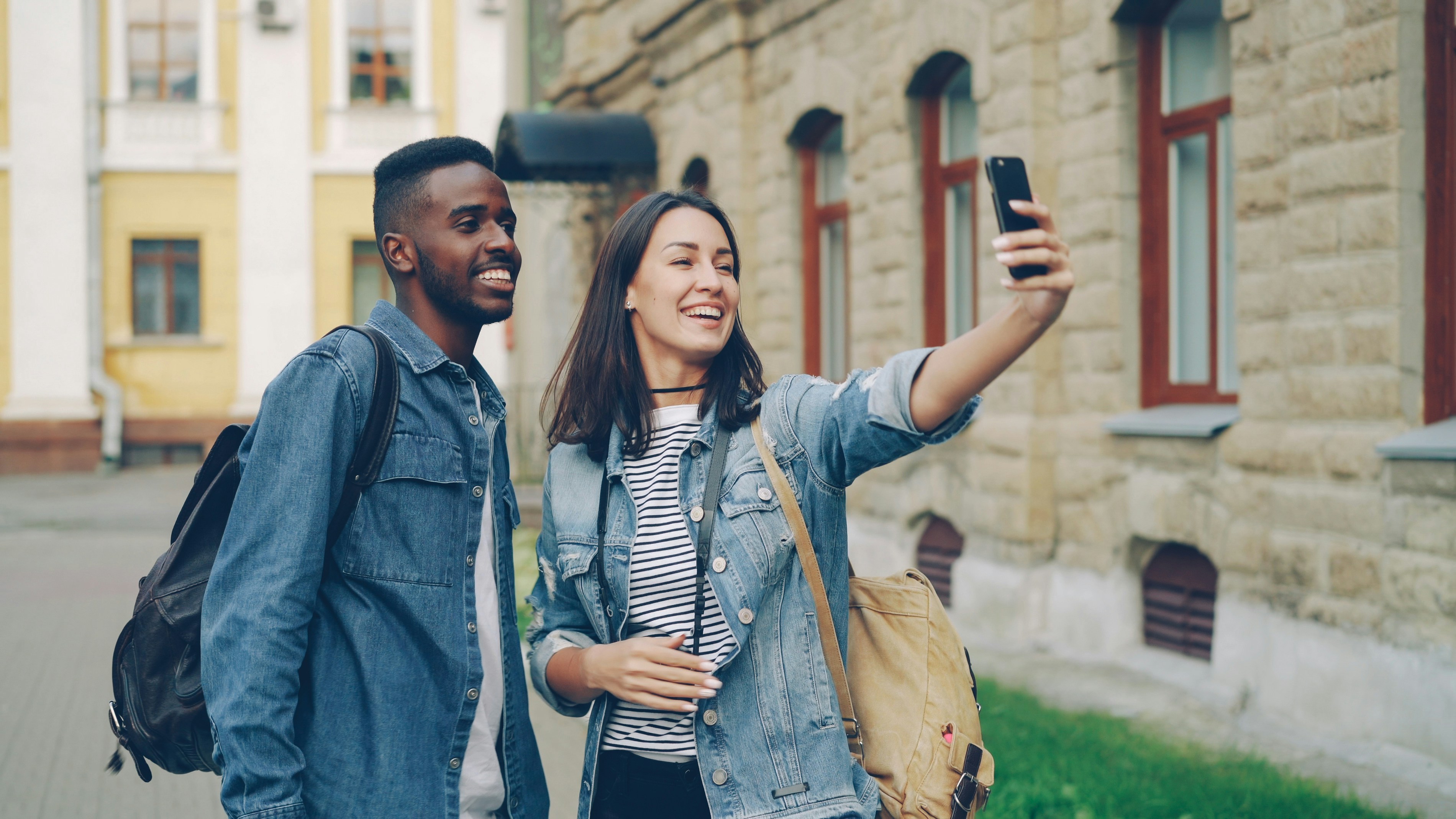 Two friends take a selfie outdoors together.