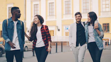 Friends are walking and smiling together outdoors.