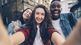 Three friends are happily taking a selfie.
