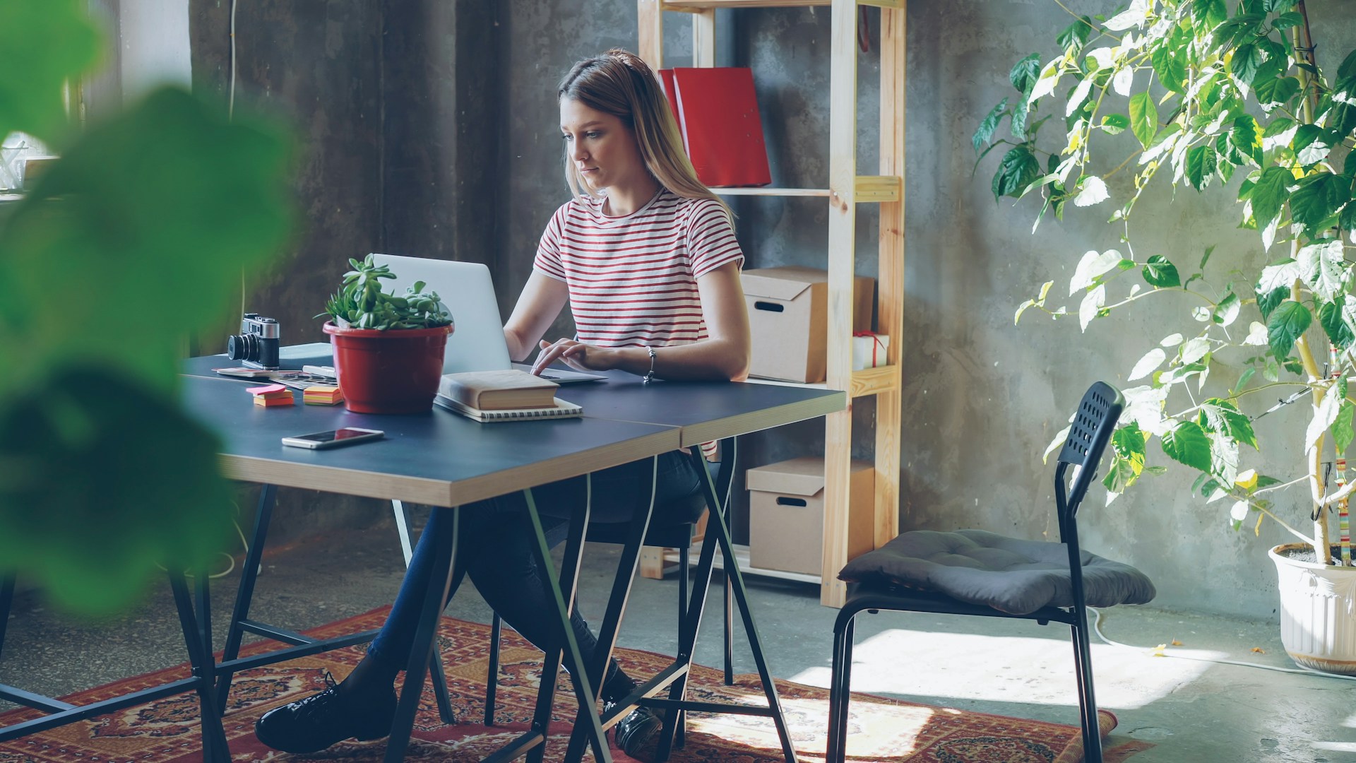 Woman works on laptop at her desk.