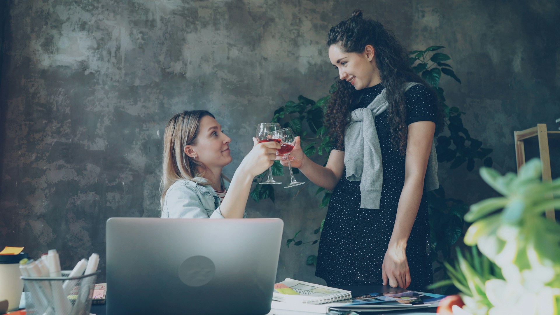 Two women toasting glasses of wine.
