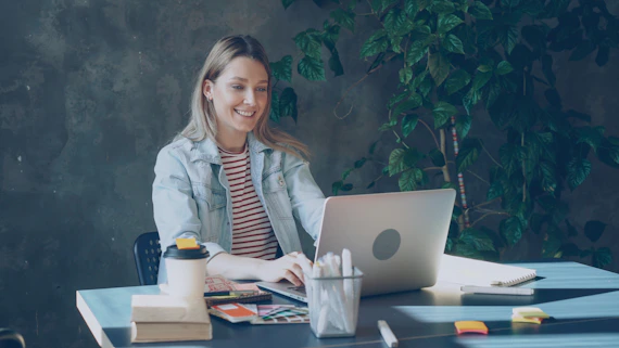 Smiling woman works on her laptop