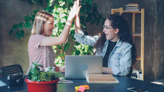 Two women celebrate success with a high five.