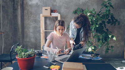 Two women collaborate at a desk.