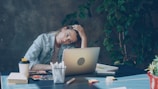 A woman appears stressed while working on laptop.