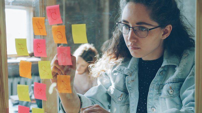 Student arranging sticky notes to plan an assignment