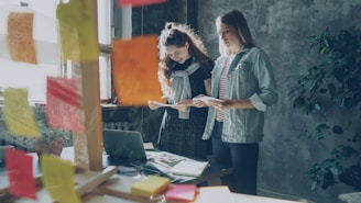 Two women work on a project in an office.